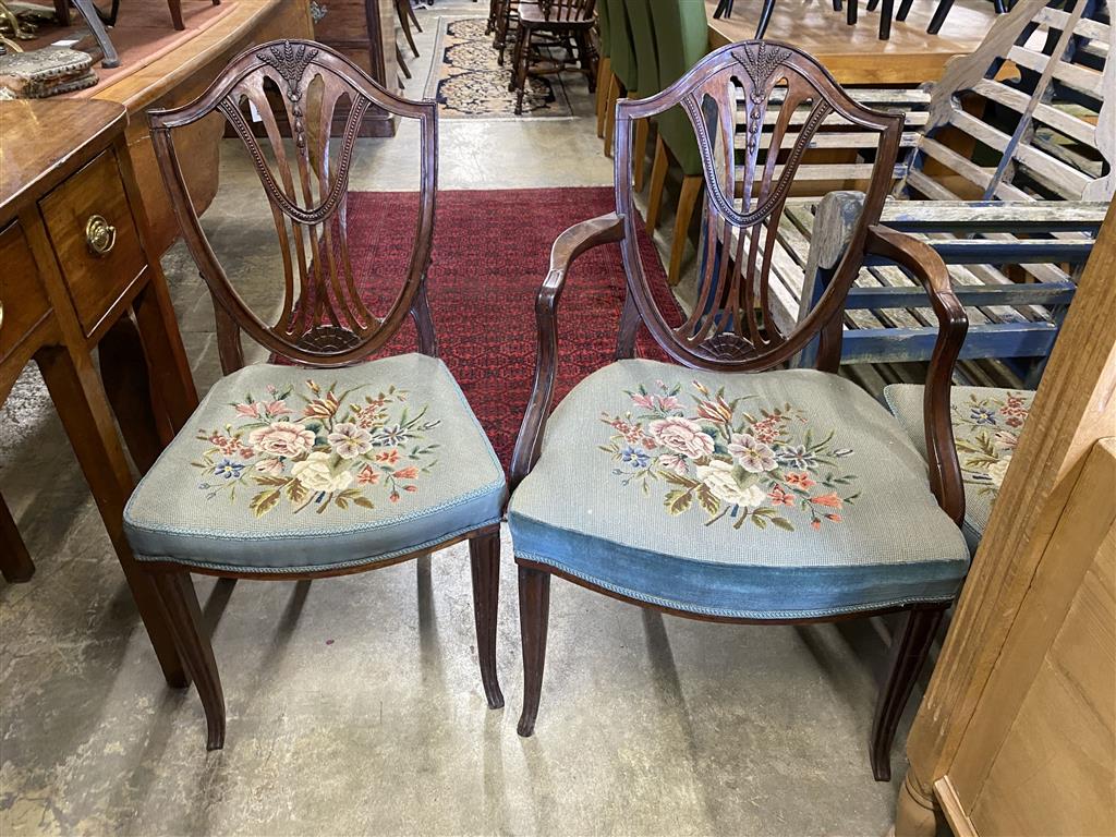 A set of six Hepplewhite style mahogany shield back dining chairs with tapestry drop in seats (two with arms)